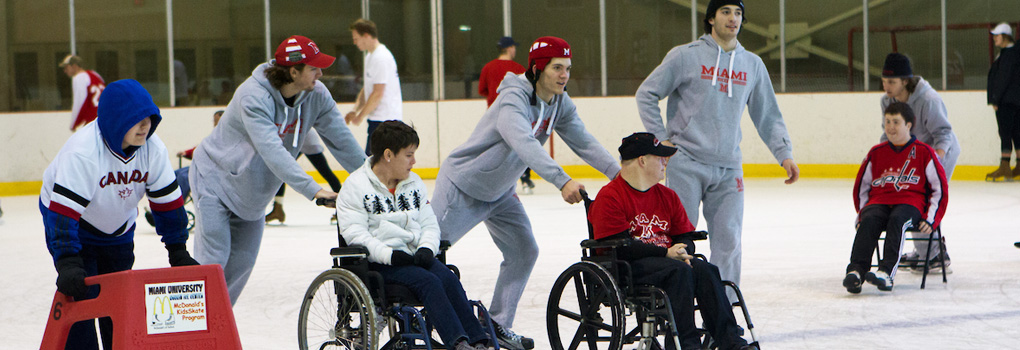  Members of Best Buddies being wheeled around ice rink by Miami hockey players