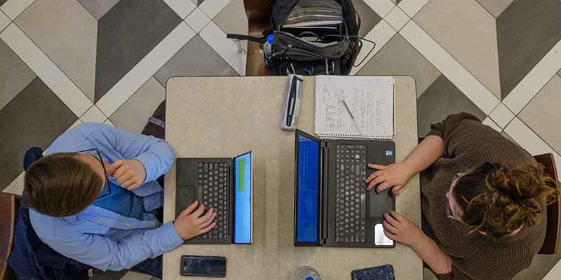 Aerial view of students sitting opposite each other working on their computers