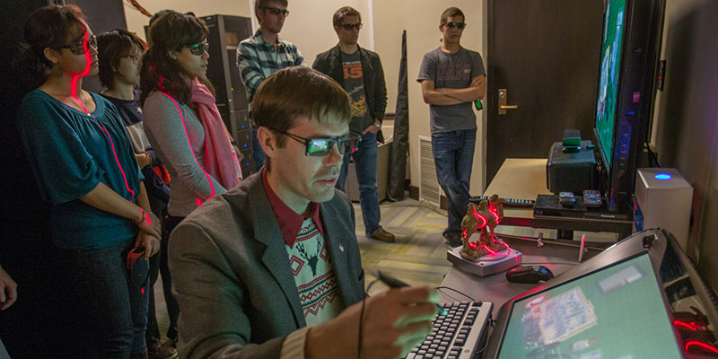 A professor showing his students, all wearing special glasses, a 3-D program