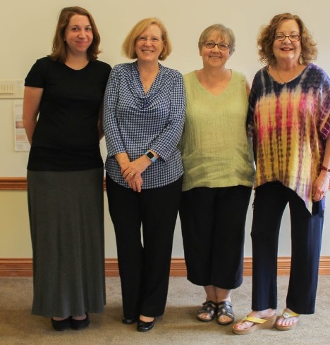 Kate Ronald, standing, with 3 Howe staff members.