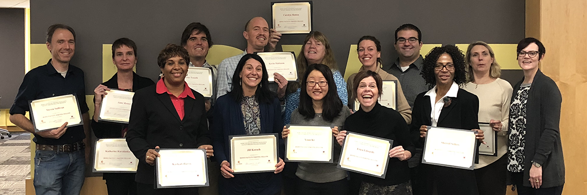 A large group of faculty fellows pose for a photo, all holding certificates.
