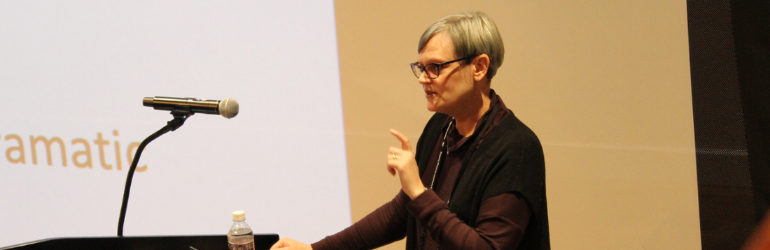 Liz Wardle lecturing in front of a microphone 