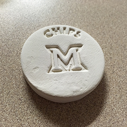 A white chip with the Miami M stamped in