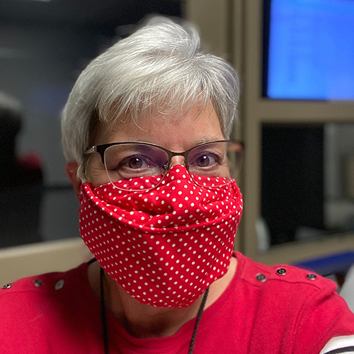 A woman with a red polka dot mask and glasses