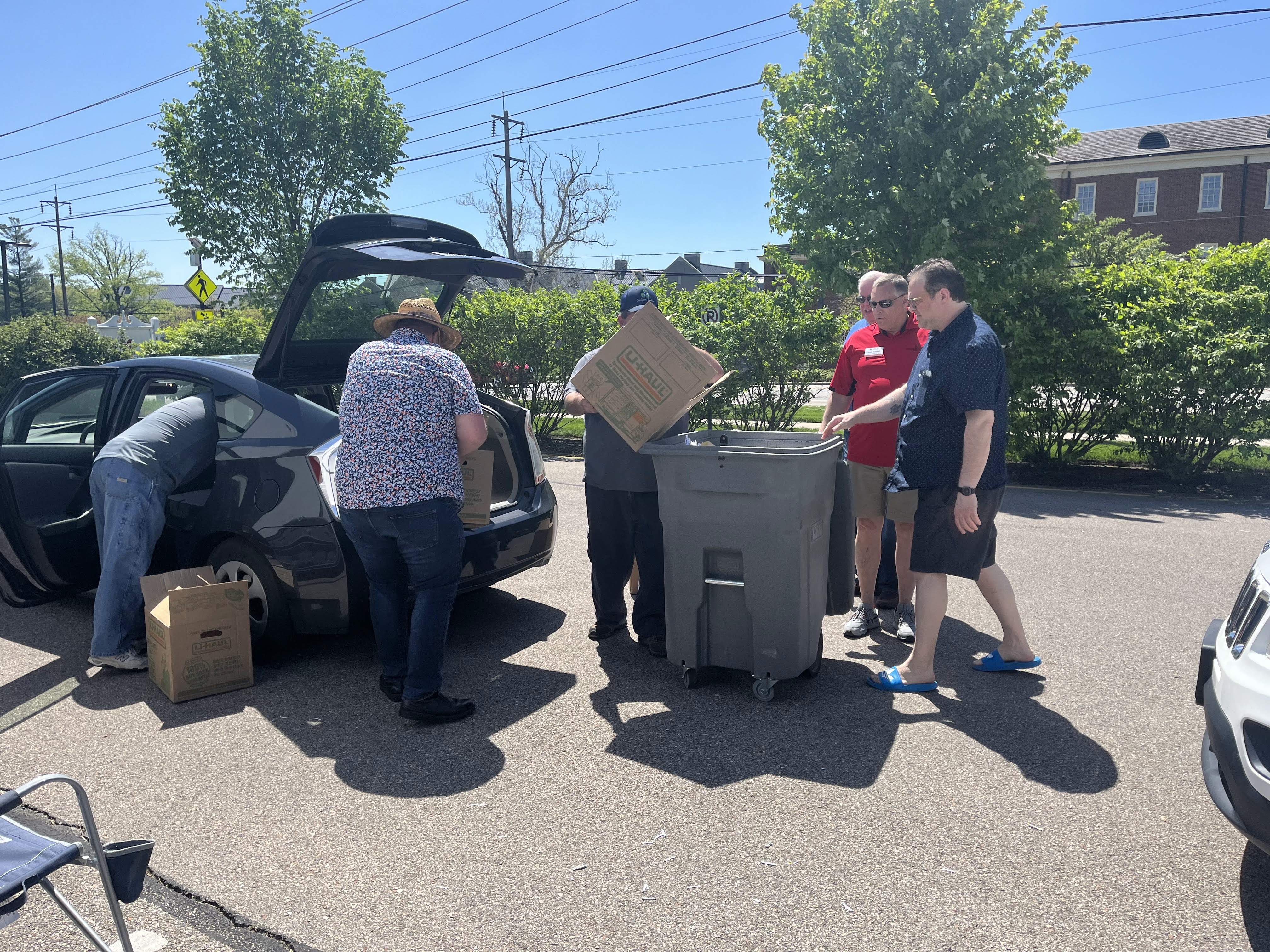 A group of volunteers loading a bin with paper to be shredded