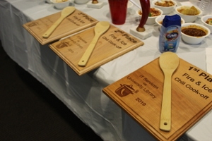 The winners' plaques for the chili competition. Wooden boards with 1st place, 2nd place, and 3rd place engraved.