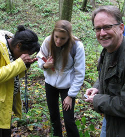 Nicholas Money and students examine botany specimens in the field