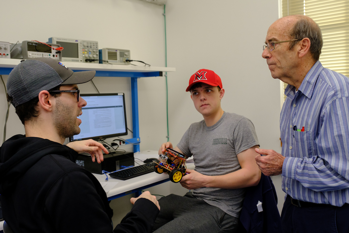Two students with Jim Leonard in robotics lab