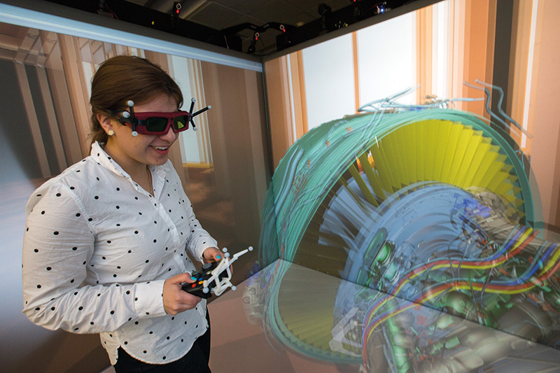 Miami student wearing 3D augmented reality goggles as she works in a lab