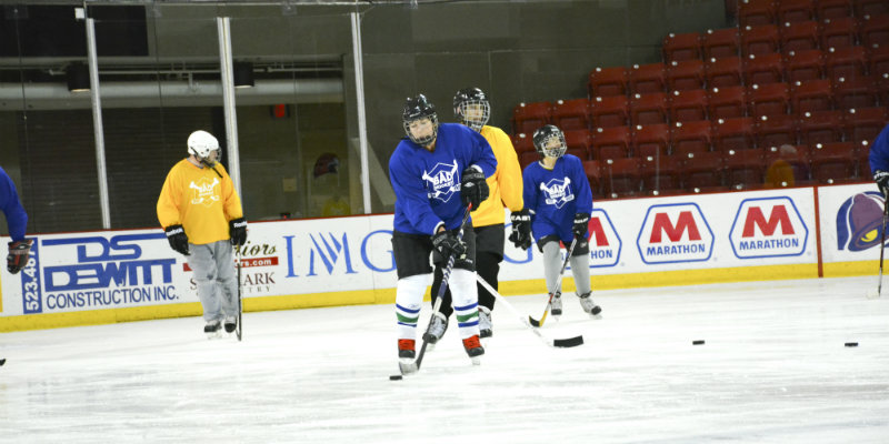 Blue and yellow hockey teams playing