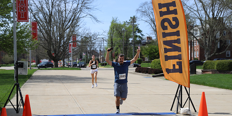  Runner with raised arms crossing the finish line