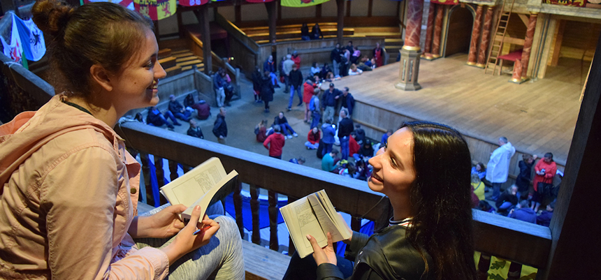  Two students with books chat at the Globe Theatre