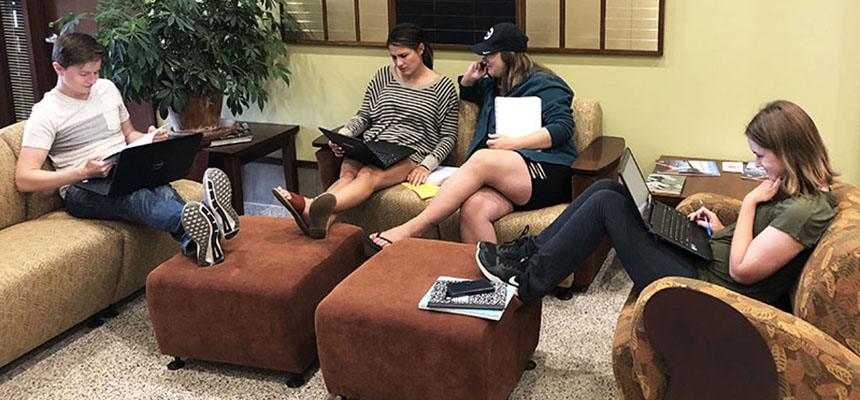 Students working in comfortable lobby seating