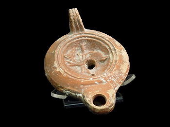 a Roman oil lamp with a dolphin on it