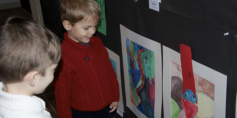 Two children admire artwork in a Saturday Art exhibition