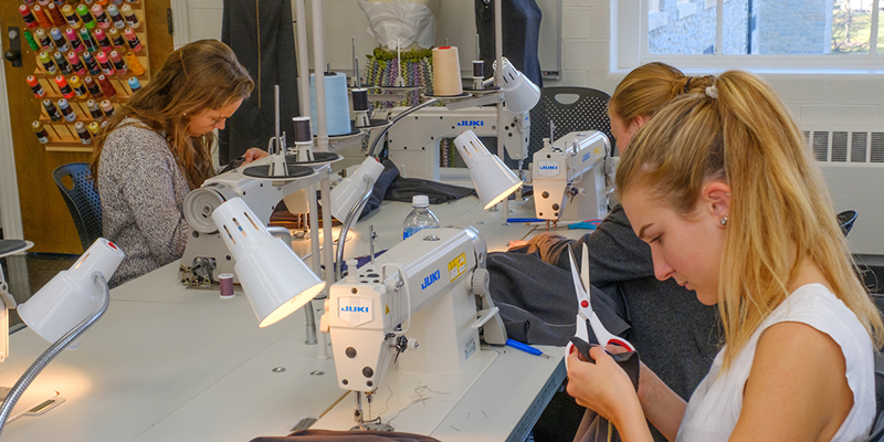Students working at a table in the fashion design classroom