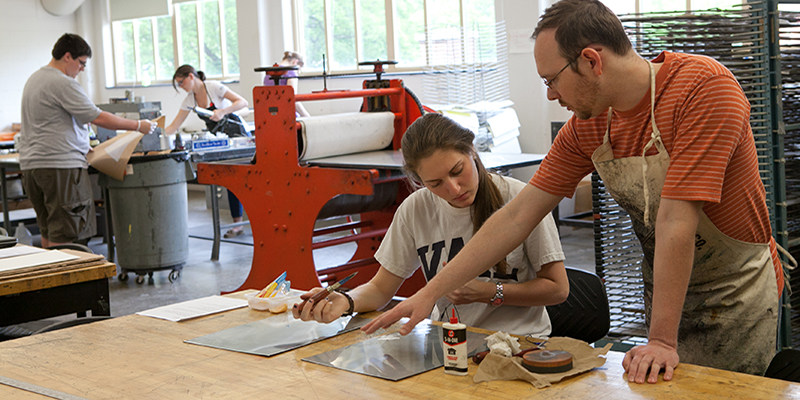 A grad student works with an undergrad on a metals project