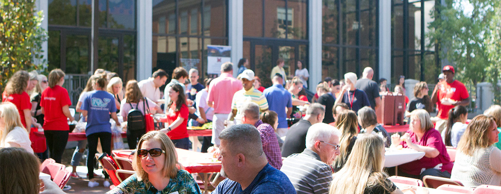 Families, students, and staff enjoy an outdoor picnic in front of the CPA