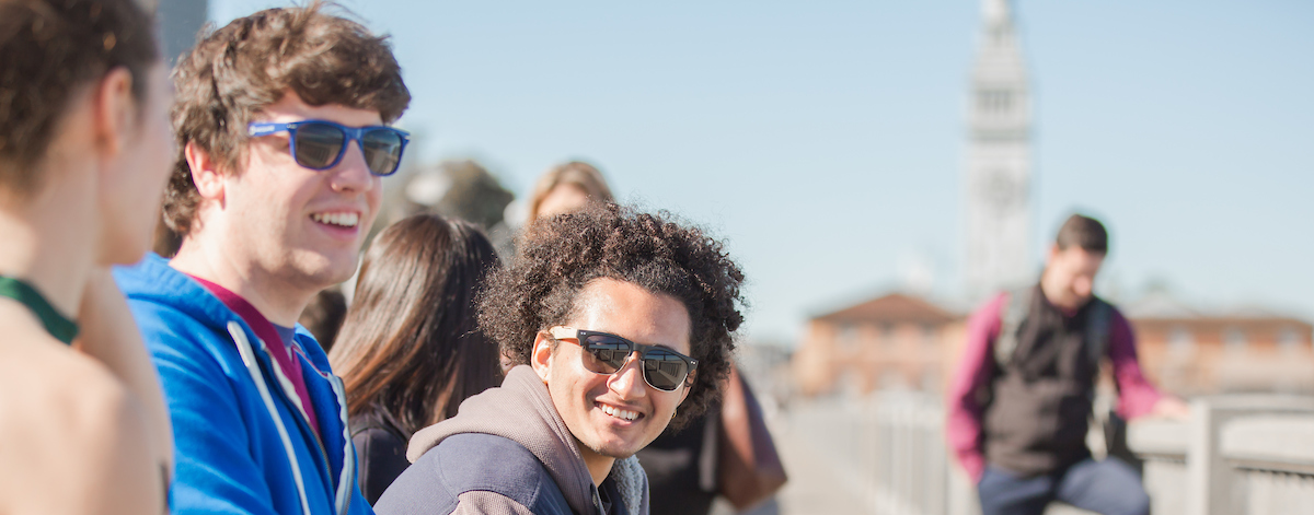 Students sit on a bench and chat near the beach in San Francisco