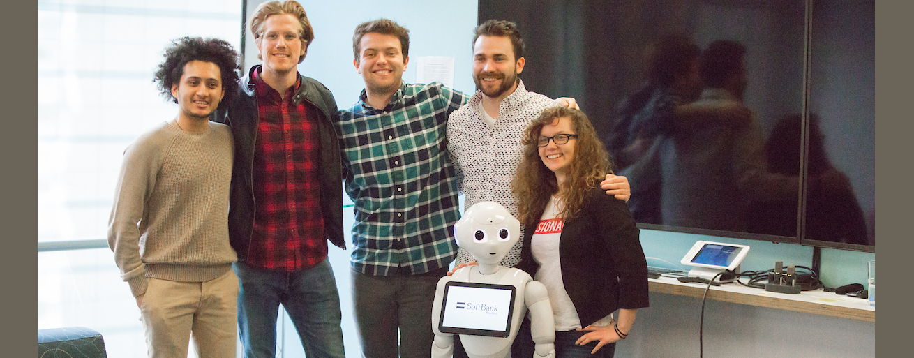 San Francisco students and alumni pose with a humanoid robot