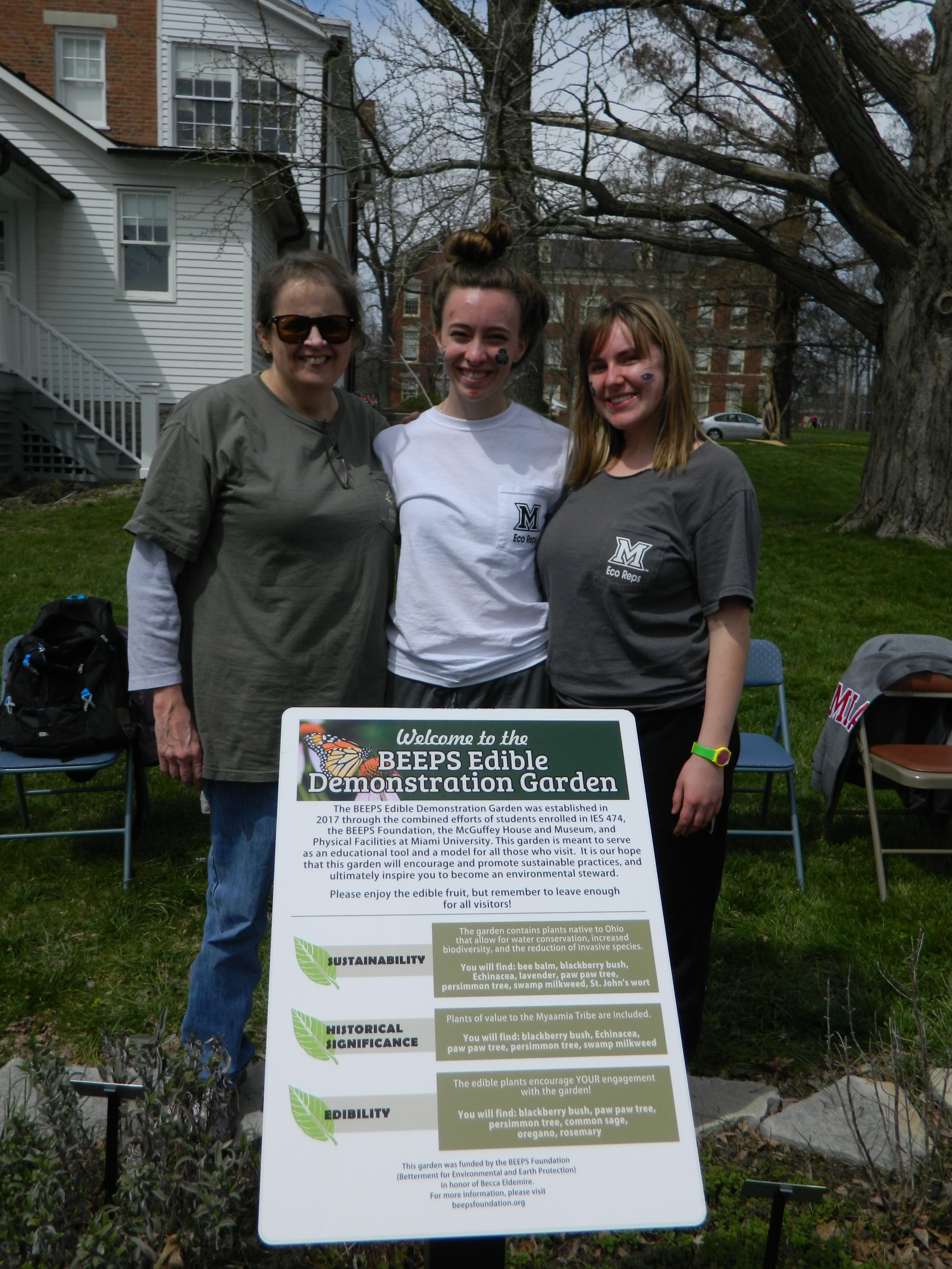 Students pose in front of a poster advertising the BEEPS garden at McGuffey House