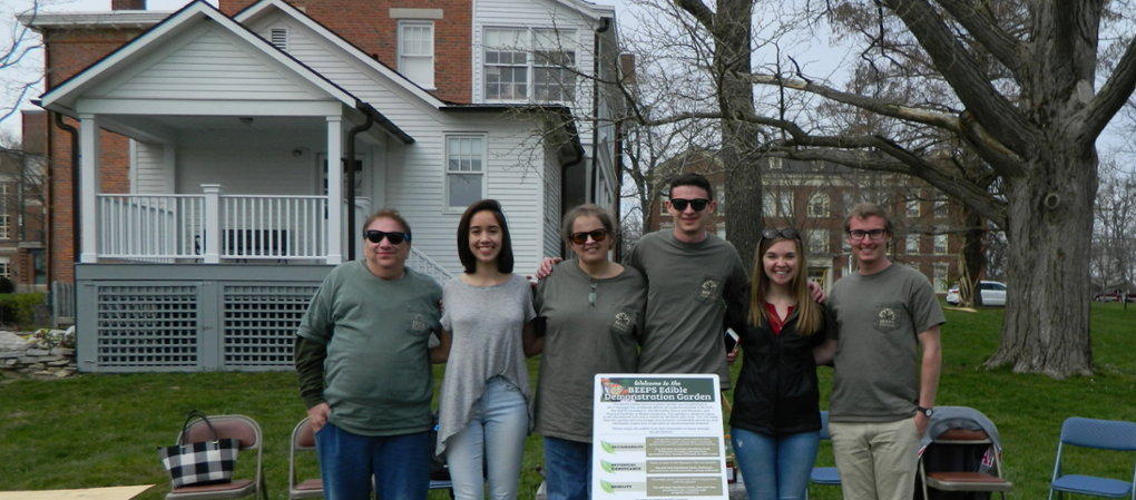 A group of volunteers pose near the BEEPS garden, behind the McGuffey house
