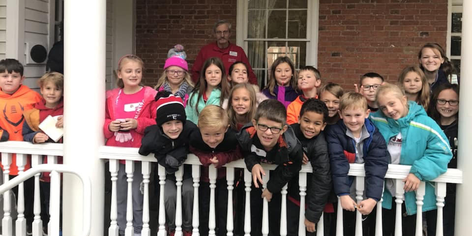 Students, teachers and parents from St. James School, Cincinnati, pose on the side porch of the McGuffey House