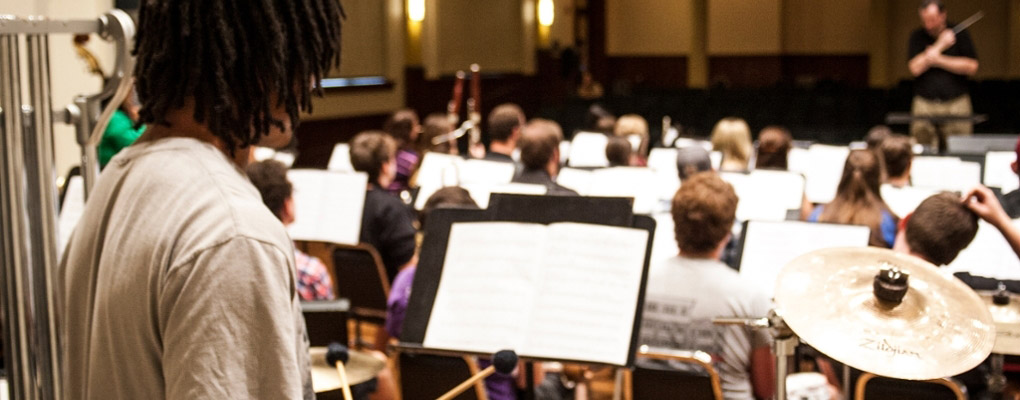  A percussionist looks from the back of the stage toward the conductor during a Wind Ensemble performance, 2015