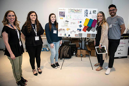 students pose with a posterboard at design charette