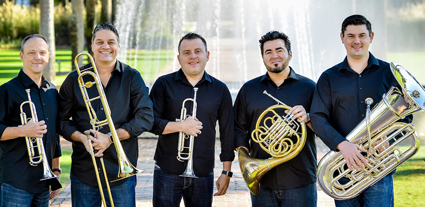 Boston Brass ensemble members holding their instruments, two trumpets, a trombone, a french horn and a tuba