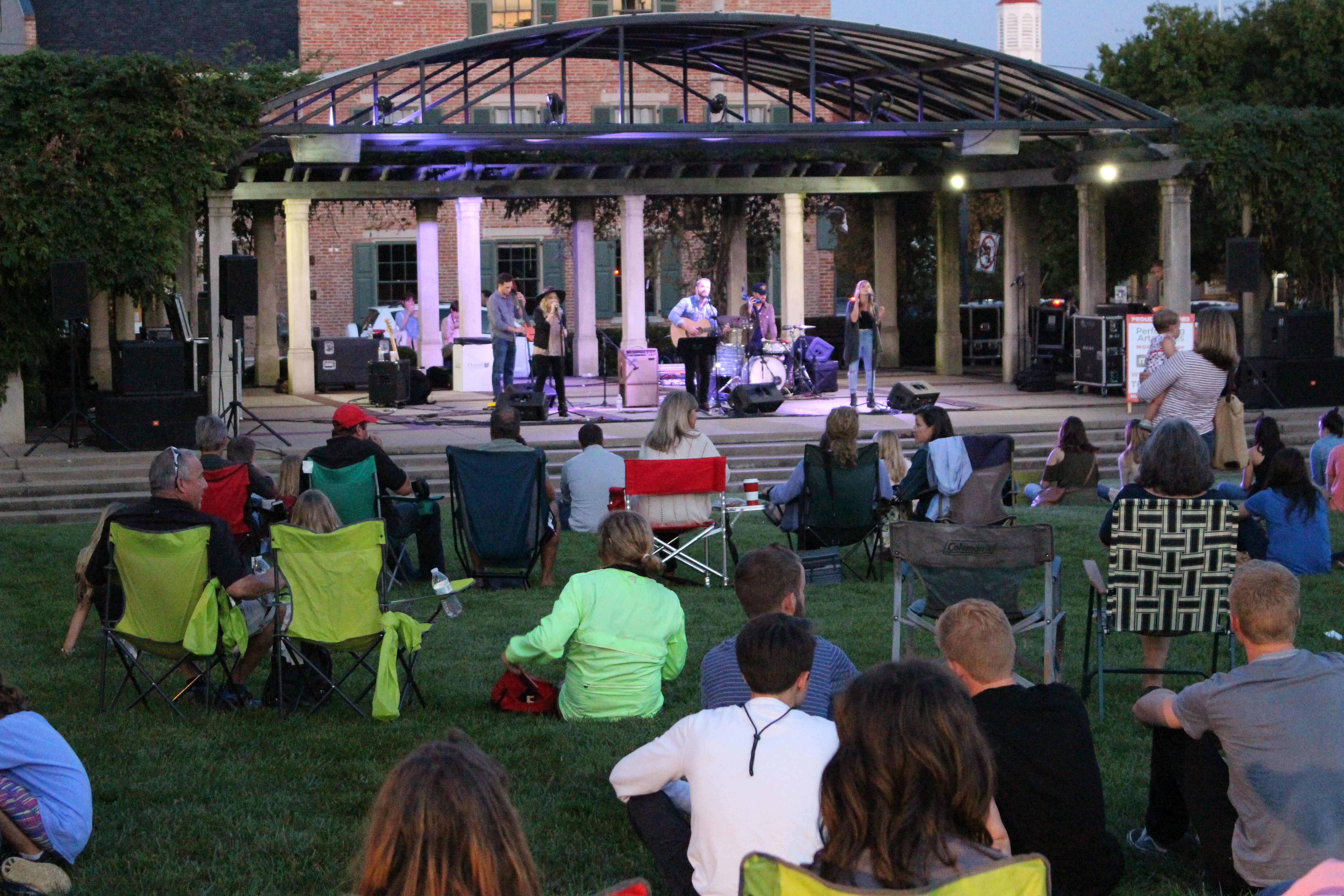 The Bundys performing at Uptown Park with audience in sitting in chairs on the lawn