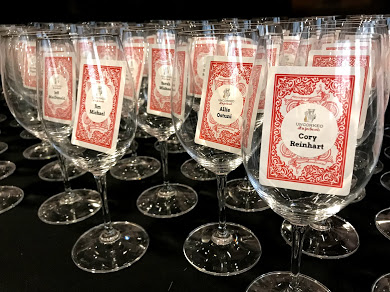 Beverage glasses arrayed on a table. Each glass contains a printed name card.