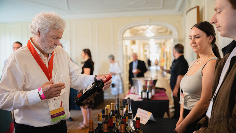An attendee examines a wine label after having a taste 
