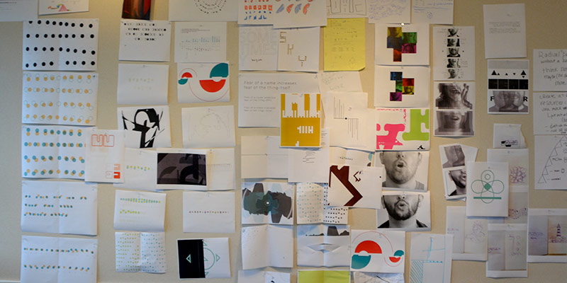 student-work-wall a wall in the studio with lots of design work like sketches posted