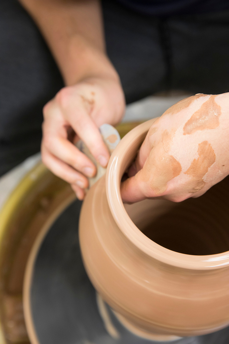 student creating pottery