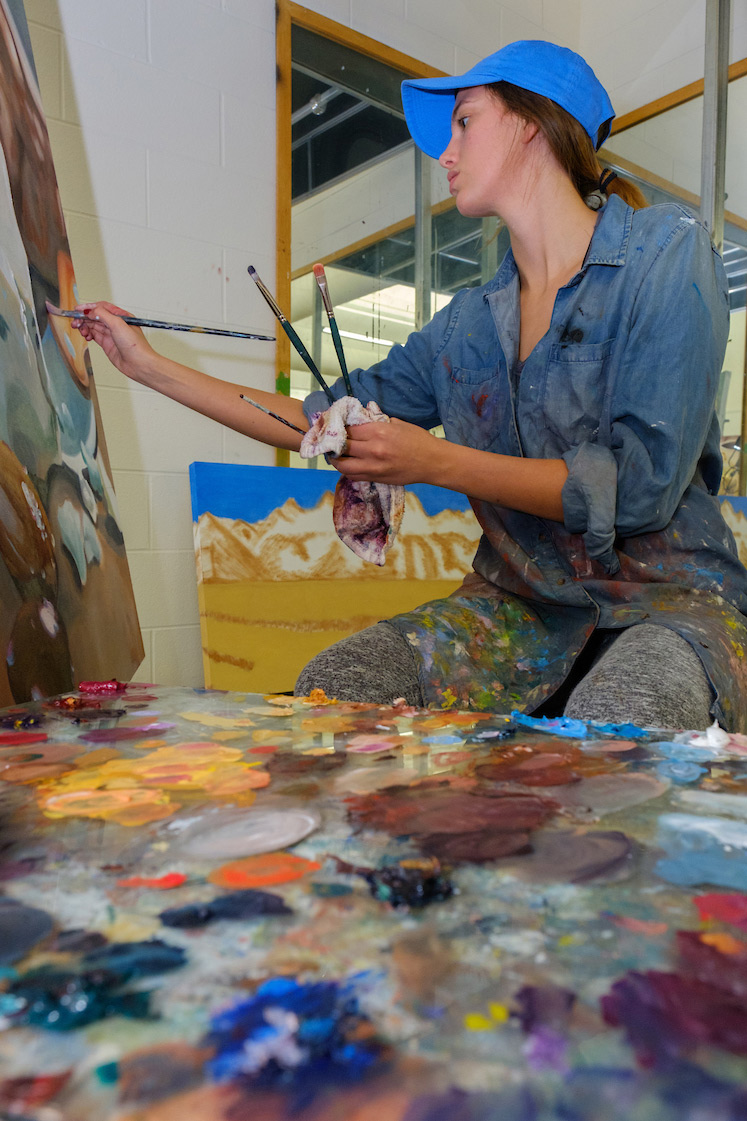 student painting on a canvas
