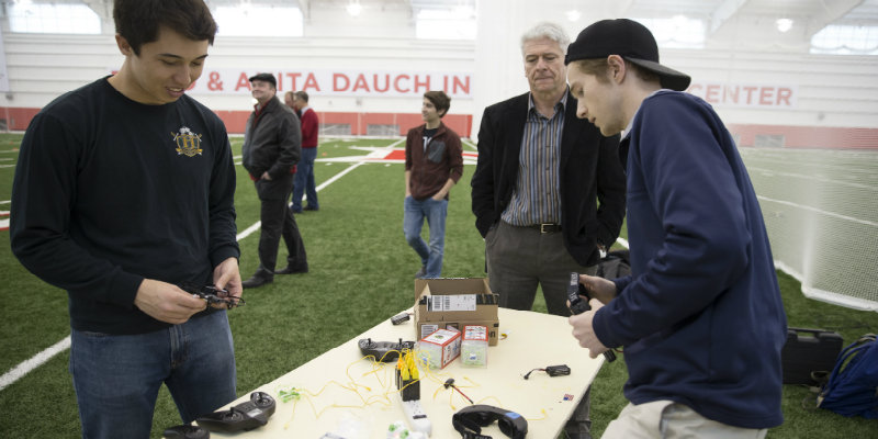 2 male students working on a drone with Dean Dollar