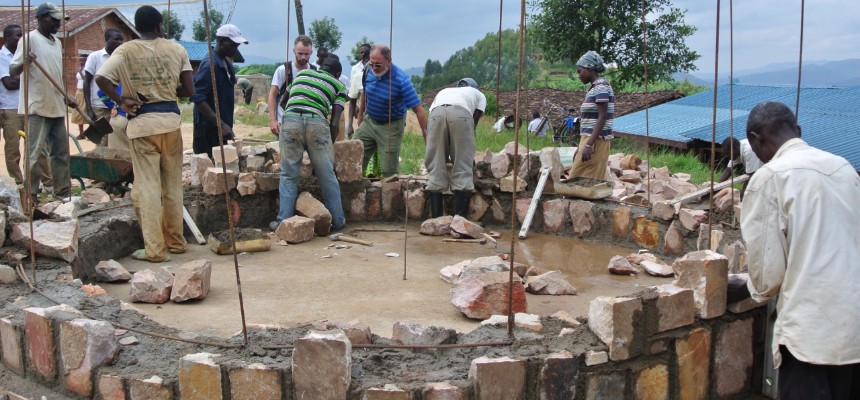 Study abroad group of students and locals building a water tank
