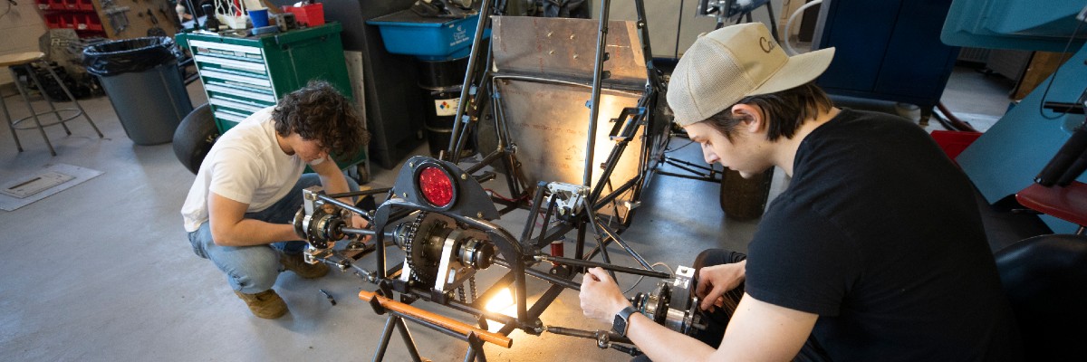 Two students working on a baja car