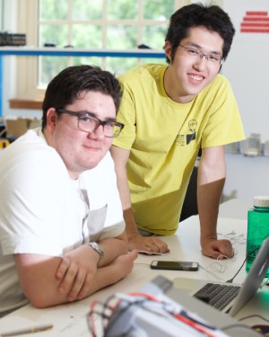 Two electrical and computing engineering students working at a laptop.