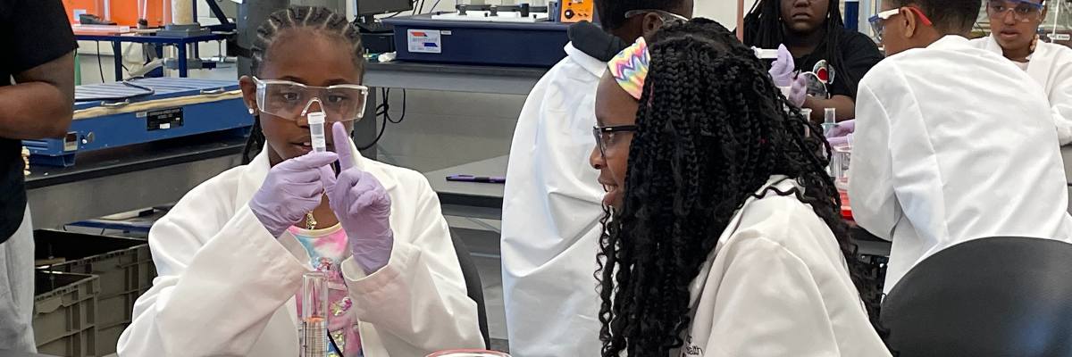 Students from the Cincinnati Summer Experience in lab coats experimenting