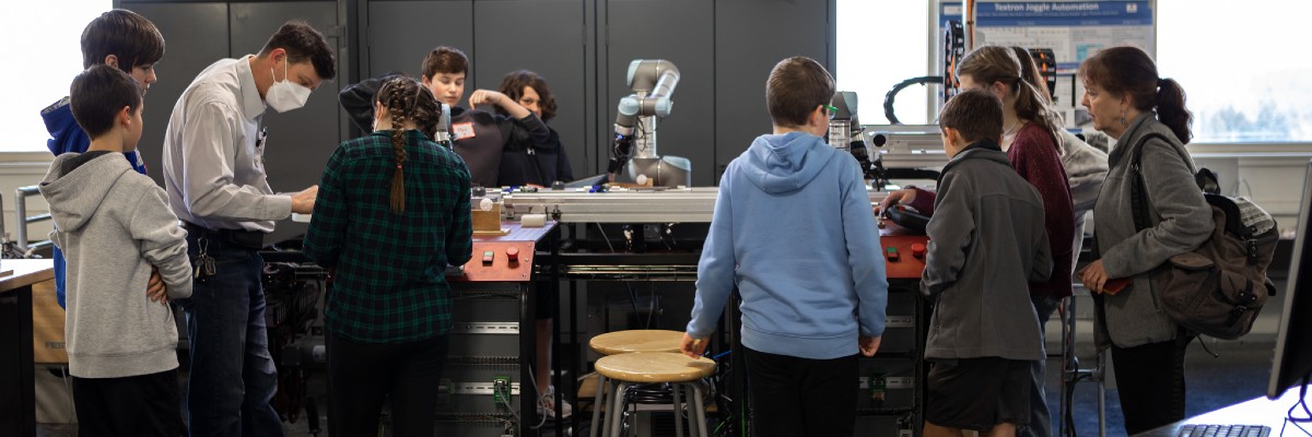 Talawanda Middle School students using robotic arms with the help of a faculty member
