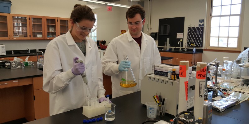 Two students mixing a solution in a CPB lab