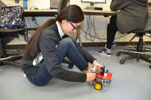 A female student working on an ECE project on the floor