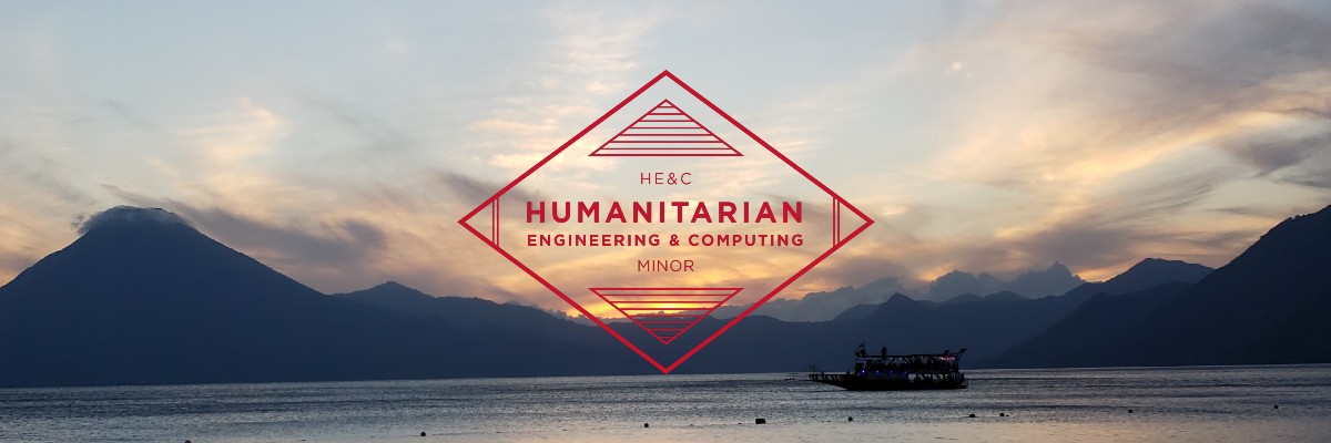 A boat on the water as the sun sets behind mountains with a badge that says Humanitarian Engineering & Computing Minor