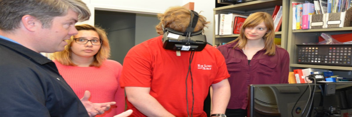 Dr. Brinkman and 3 students working with augmented reality goggles