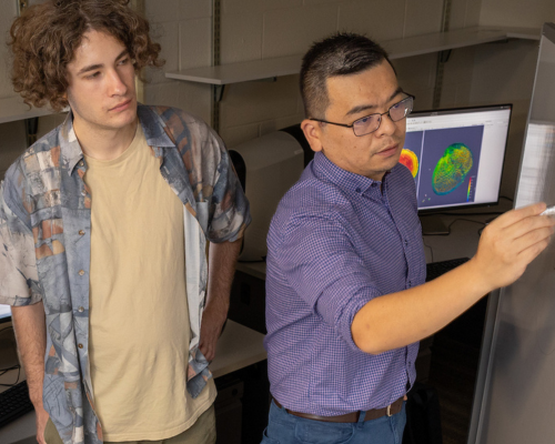 Serhii Reznichenko and Assistant Professor Zhou work on a research project.