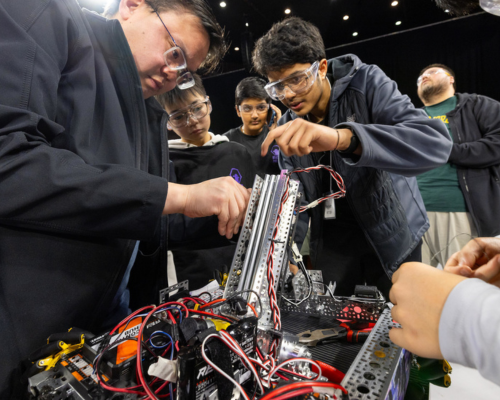 A robotics team adjusts their robot ahead of competition at Millett Hall.