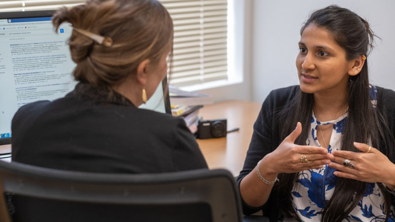 Akanksha Das talking with another person inside a Miami psychology lab