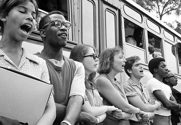 Freedom Summer participants holding hands while singing together